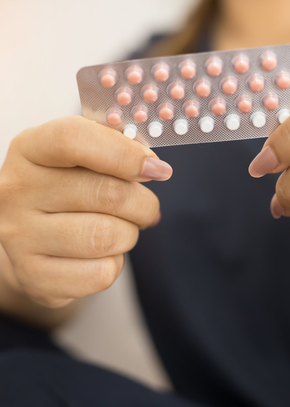 weiblich gelesene Person hält Packung der Antibabypille in der Hand, fenou reset pille absetzen